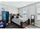 Bedroom features dark wood frame bed with patterned bedding, black and white rug, neutral walls, and a window at 123 Hewitt St, Summerville, SC 29486