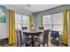 Sunlit dining area featuring a round table, four chairs, and yellow curtains at 124 Gaura Ln, Summerville, SC 29483