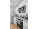 Stainless steel appliances including a microwave and range, complimented by white cabinetry in this bright kitchen at 124 Gaura Ln, Summerville, SC 29483