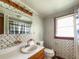 Traditional bathroom with wood vanity, standard toilet, wallpaper, and vanity lights at 1393 Russellville Rd, Saint Stephen, SC 29479