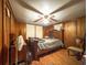 Bedroom with a ceiling fan, a bed, wood-look floors, and wood-paneled walls at 1393 Russellville Rd, Saint Stephen, SC 29479