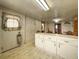This shows the kitchen with white cabinets, a light, and decorative wall paper at 1393 Russellville Rd, Saint Stephen, SC 29479