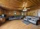 Living room featuring wood-paneled walls, a ceiling fan, comfortable seating, and laminate wood flooring at 1393 Russellville Rd, Saint Stephen, SC 29479