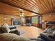 Inviting living room featuring wood-paneled walls, a brick fireplace, comfortable seating, and laminate flooring at 1393 Russellville Rd, Saint Stephen, SC 29479