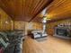 Cozy living room with wood-paneled walls and a brick fireplace, showcasing comfortable seating and a ceiling fan at 1393 Russellville Rd, Saint Stephen, SC 29479