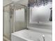 Relaxing bathroom boasts a tub with jets, a shower with both fixed and handheld showerheads, and a window for natural light at 1428 Bloomingdale Ln, Mount Pleasant, SC 29466