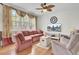 Comfortable living room featuring a patterned sofa, a ceiling fan, and large windows with stylish curtains at 1428 Bloomingdale Ln, Mount Pleasant, SC 29466