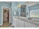 Bright bathroom with double vanity, a glass block window, and a walk-in closet with storage at 144 Back Tee Cir, Summerville, SC 29485