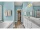 Bright main bathroom featuring double sinks, soaking tub, walk-in closet, and stylish fixtures at 144 Back Tee Cir, Summerville, SC 29485