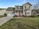 Charming two-story home with a red door, landscaped yard, attached garage, and well-maintained lawn at 159 Antebellum Way, Summerville, SC 29483