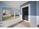 A welcoming front porch featuring a black front door, concrete flooring, and a view of a well-maintained yard at 173 Paddle Boat Way, Summerville, SC 29485
