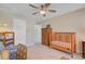 Neutral bedroom with a ceiling fan, wooden baby crib, and a closet for ample storage at 1807 Chauncy'S Ct, Mount Pleasant, SC 29466