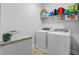 Functional laundry room with washer, dryer, shelving, and a folding table at 1807 Chauncy'S Ct, Mount Pleasant, SC 29466