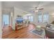 Bright and airy living room with hardwood floors, ceiling fan, and a partial view into the kitchen at 1822 Chatelain Way, Mount Pleasant, SC 29464