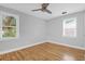 Empty bedroom featuring hardwood floors, two windows, and a ceiling fan at 1873 Hazelwood Dr, Charleston, SC 29407