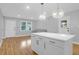 Bright, open kitchen features white cabinets, a large island, and stylish pendant lighting, with a view to a living area at 1873 Hazelwood Dr, Charleston, SC 29407