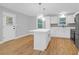 Open kitchen layout with white cabinets, stainless steel appliances, and large island with elegant pendant lighting at 1873 Hazelwood Dr, Charleston, SC 29407