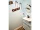 Modern powder room features an elegant sink, decorative artwork, and a stylish mirror at 212 Chester Ln, Cottageville, SC 29435