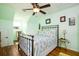 Bedroom with decorative iron bed frame, wood laminate floor, and ceiling fan at 212 Chester Ln, Cottageville, SC 29435