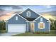 Charming blue house featuring a well-maintained lawn, white garage door, and beautiful landscaping at 2196 Macallan Blvd, Ravenel, SC 29470