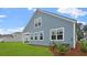 Two-story light-blue home with multiple windows on the side, framed by a green lawn at 2196 Macallan Blvd, Ravenel, SC 29470