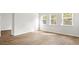 Bright living room featuring hardwood floors, white trim, and three large windows at 2196 Macallan Blvd, Ravenel, SC 29470