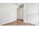 A cozy bedroom with laminate floors, neutral walls, and white doors leading to closet and hall spaces at 2250 Macallan Blvd, Ravenel, SC 29470