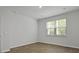 A well-lit bedroom features hardwood floors, a large window, and white walls at 2275 Macallan Blvd, Ravenel, SC 29470