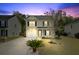 Charming two-story home with a well-manicured lawn and driveway at dusk at 236 Emerald Isle Dr, Moncks Corner, SC 29461