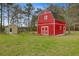Exterior of a red barn, surrounded by lush green grass, and a shed on the property at 276 S Railroad Ave, Harleyville, SC 29448