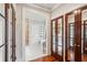 Bathroom entryway featuring dark wood paneled doors and flooring with a view of the bathtub at 3 Atlantic St, Charleston, SC 29401