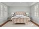 Bright bedroom with a unique patterned headboard, accompanied by two lamps and a large window with shutters at 3 Atlantic St, Charleston, SC 29401