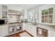 Well-lit kitchen featuring stainless steel appliances, granite countertops, white cabinets, and hardwood floors at 3 Atlantic St, Charleston, SC 29401