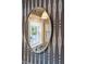 Elegant bathroom mirror reflects a sink and window, complemented by patterned wallpaper and sconce lighting at 3 Atlantic St, Charleston, SC 29401