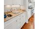 Granite countertop and white cabinets in a well-appointed wet bar area, adjacent to the kitchen at 3 Atlantic St, Charleston, SC 29401
