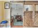 Living room view through a sliding barn door, showcasing an area rug, sofa, and modern lighting at 3016 Adventure Way, Ladson, SC 29456