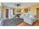 Bright living room featuring a fireplace with mantel, ceiling fan, hardwood floors, and comfortable seating at 3016 Adventure Way, Ladson, SC 29456