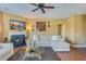 A fireplace and TV accent this comfortable living room with an area rug, fan, and an L-shaped sofa at 3016 Adventure Way, Ladson, SC 29456