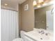 Functional bathroom features a vanity with chrome fixtures, a large mirror, and a shower-tub combination with a white curtain at 302 Palmetto Dr # A-302, Isle of Palms, SC 29451