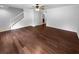 Open-concept living area featuring beautiful hardwood flooring, a ceiling fan, and a staircase with white railings at 3048 Queensgate Way, Mount Pleasant, SC 29466