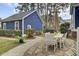 Backyard view with a patio, dining area, lush landscaping, string lights, and blue siding at 3409 Southern Cottage Way, Mount Pleasant, SC 29466