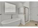 Bright bathroom featuring a freestanding tub, glass-enclosed shower, and neutral tile flooring at 3409 Southern Cottage Way, Mount Pleasant, SC 29466