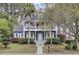 Charming two-story home with a double porch, lush landscaping, and a well-manicured lawn at 3409 Southern Cottage Way, Mount Pleasant, SC 29466