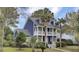 Two-story home with double porches framed by palm trees and green lawn at 3409 Southern Cottage Way, Mount Pleasant, SC 29466