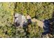 Drone shot of a home's roof, driveway, and surrounding lush trees within a community at 3475 Deer Run Rd, Seabrook Island, SC 29455