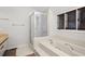 A well-lit bathroom with a shower, bathtub, and window at 3475 Deer Run Rd, Seabrook Island, SC 29455