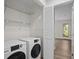 View of a laundry room with new appliances, wire shelves, and bi-fold doors at 3475 Deer Run Rd, Seabrook Island, SC 29455