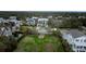 Neighborhood aerial view showcases a pristine property, lush greenery and a stately home at 3803 Palm Blvd, Isle of Palms, SC 29451