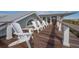 Relaxing balcony with white Adirondack chairs and scenic views of the surrounding landscape at 3803 Palm Blvd, Isle of Palms, SC 29451
