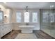 Bright bathroom features a soaking tub under three windows and a separate tiled shower at 3803 Palm Blvd, Isle of Palms, SC 29451